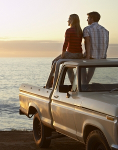 young couple on pick-up truck parked in front of oc